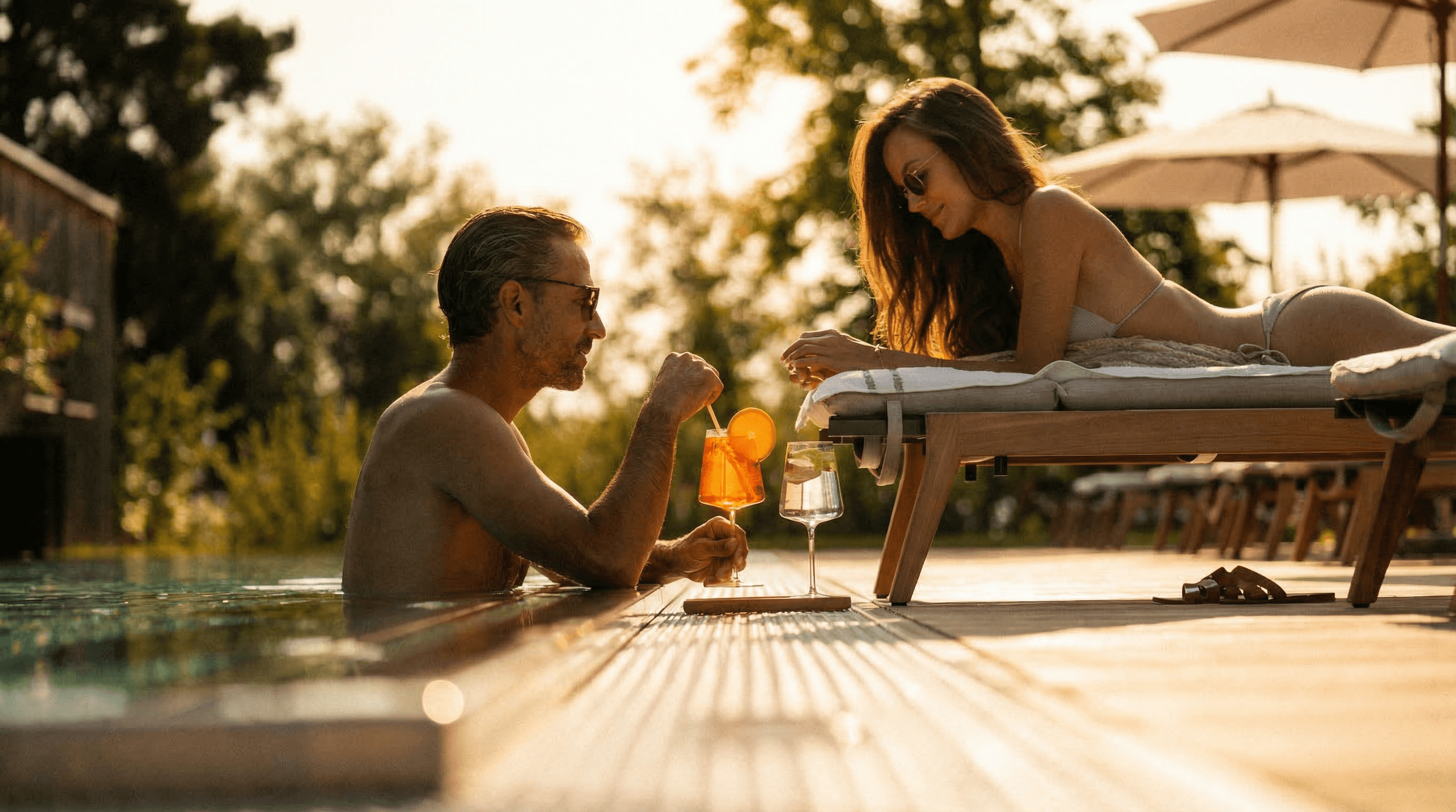 Couple in their 40s relaxing by the pool at sunset, warm and intimate
